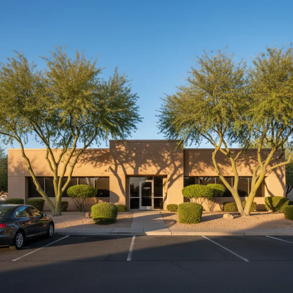 domestic-violence-defense-law-office-exterior-mesa-stapley-dr Exterior of a single-story Mesa, Arizona law office building with desert landscaping at golden hour.